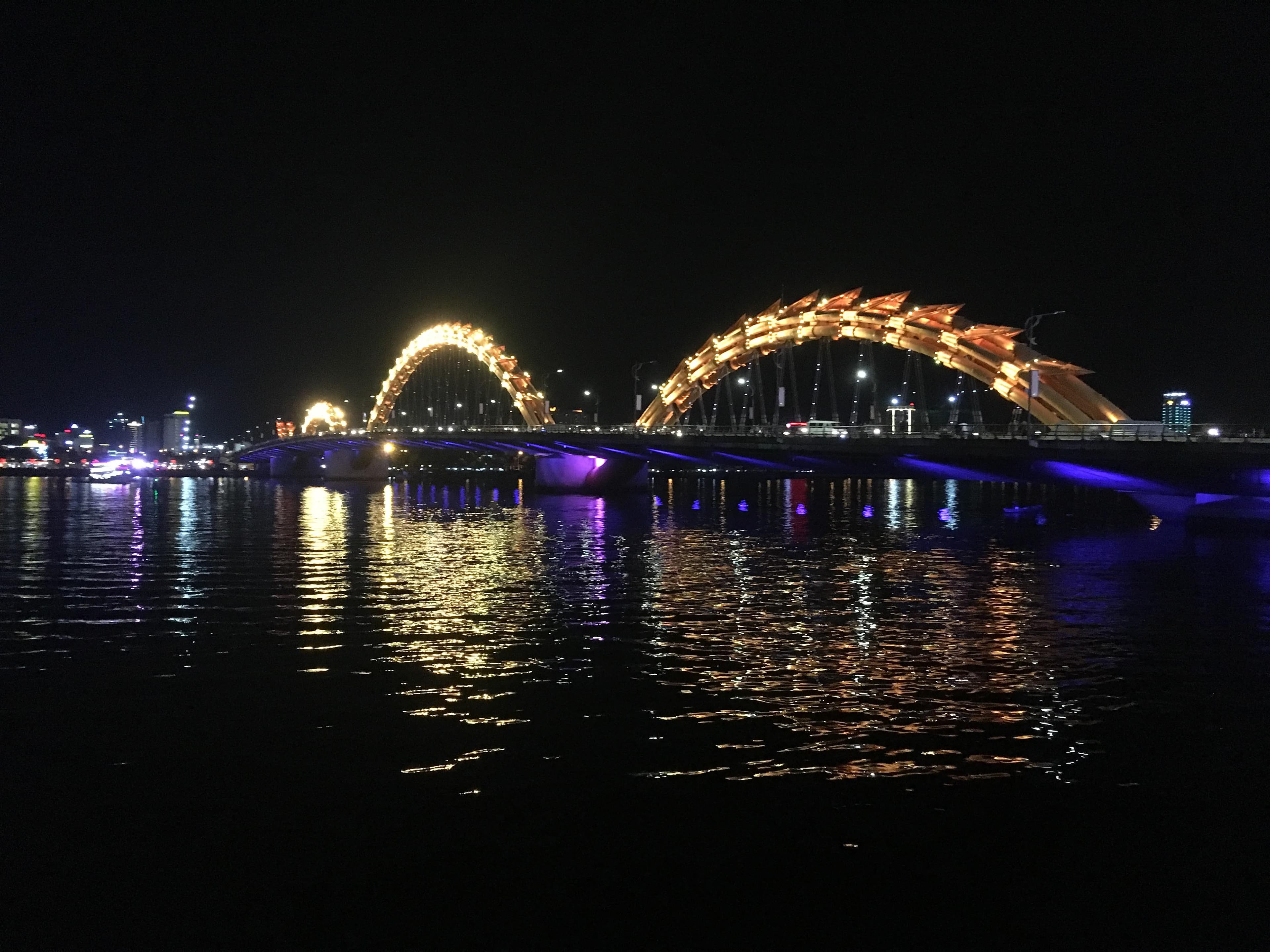 The Dragon Bridge in Da Nang lit up in color at night over the Han River